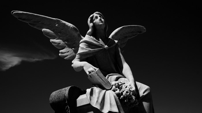 Angel statue with book and flowers