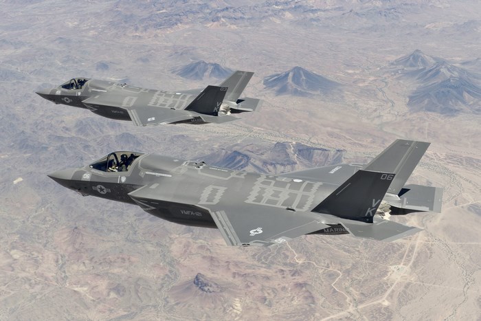 Lockheed Martin F-35 Lightning II jets flying over desert mountains