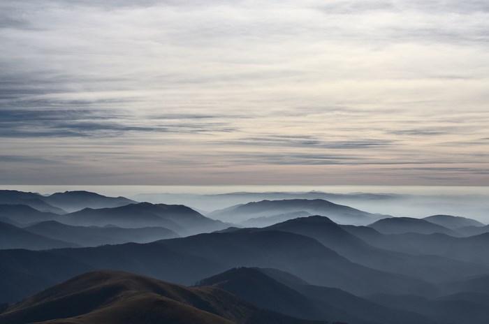 Layered mountain range under a cloudy sky