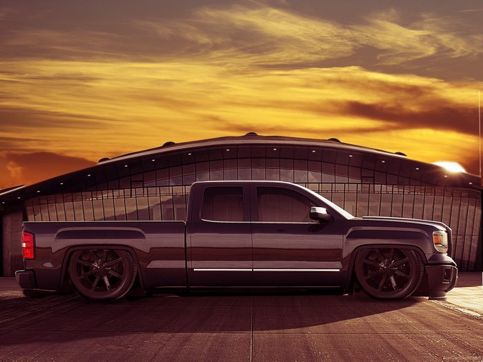 Custom GMC Sierra pickup truck at sunset