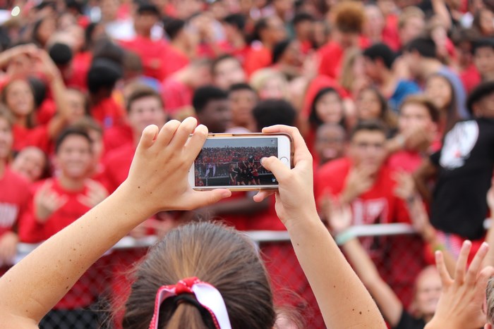 Person filming a crowd with an iPhone