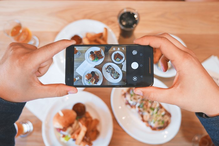 Person taking a photo of food with a smartphone