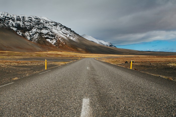 Asphalt road through a snowy mountain landscape in Iceland