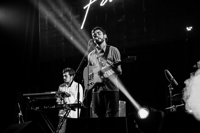 Band performing on stage with guitar and keyboard