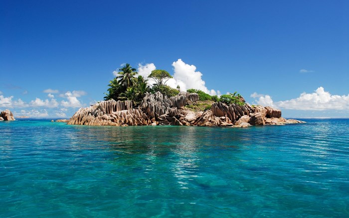 Island with palm trees and rocks in the ocean
