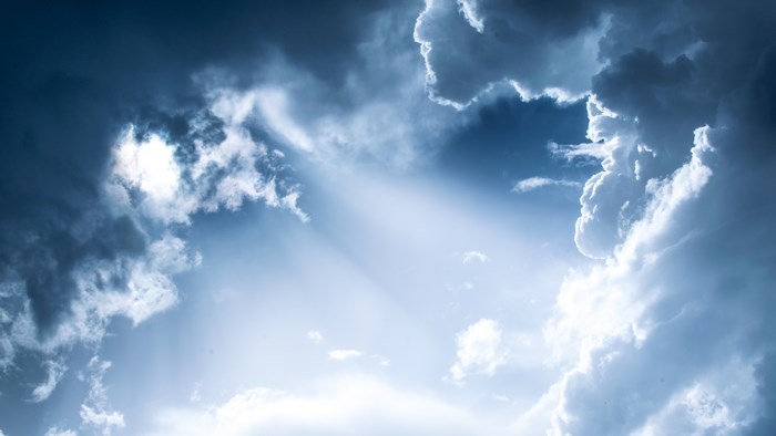 Sunlight rays through dramatic clouds in a blue sky
