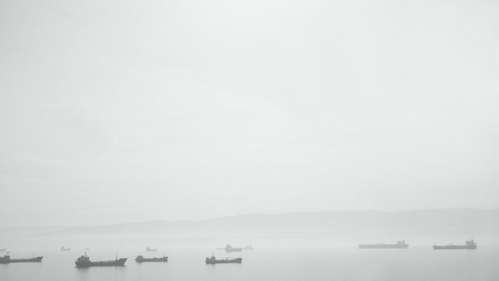 Ships on the water in a foggy haze
