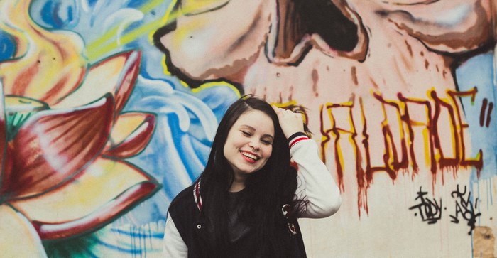 Woman with nose ring in front of graffiti wall