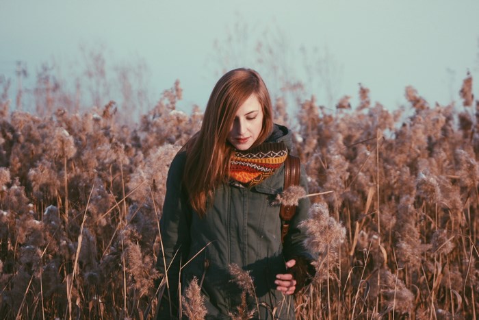Woman with red hair in a field of tall grass