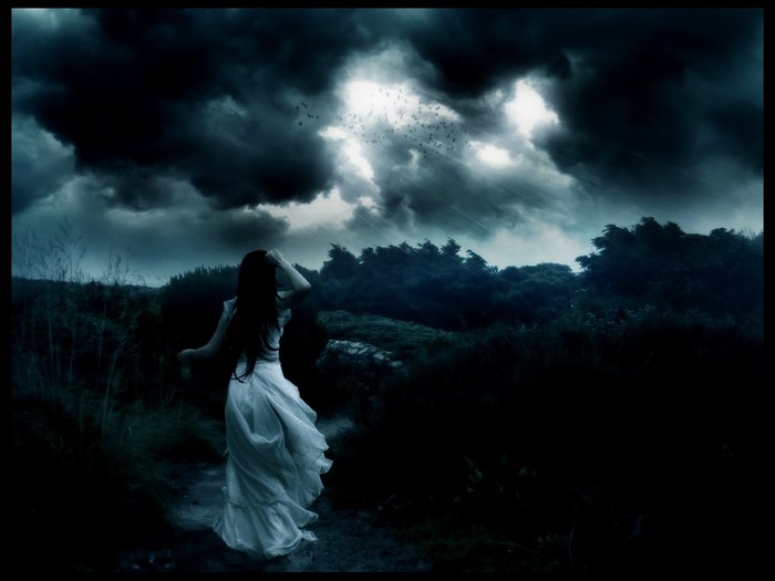 Mysterious woman in white dress under stormy sky