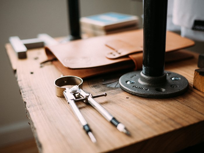 Compass and leather notebook on a wooden table