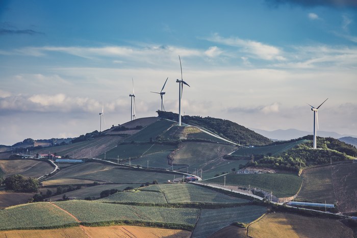 Wind turbines on rolling hills with fields