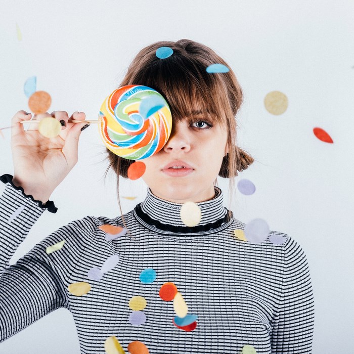 Girl with lollipop and confetti