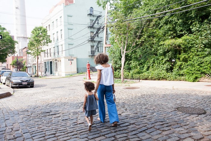 Mother and daughter walking on a cobblestone street