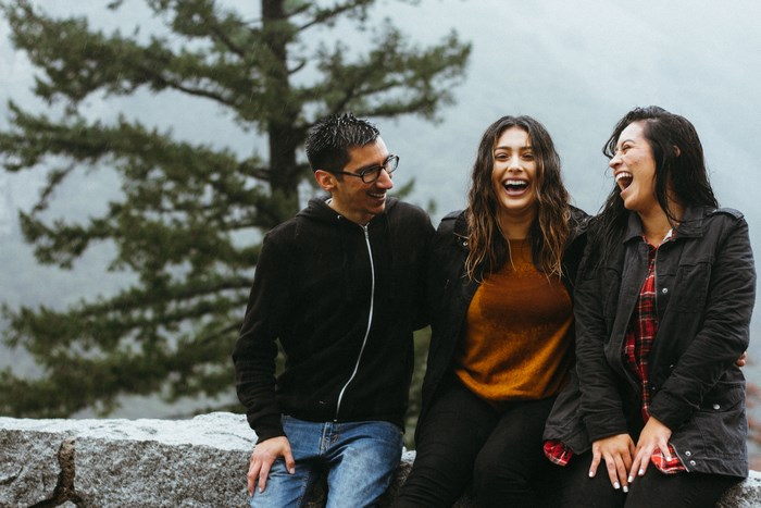 Three friends laughing in the rain