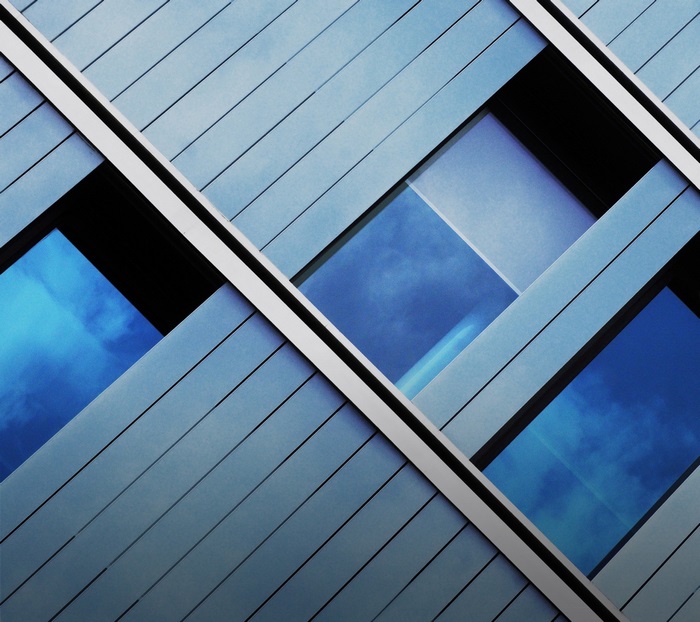 Modern building facade with blue sky reflections