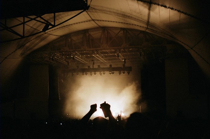 Concert crowd with hands up in smoke