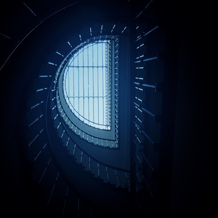 Looking up a spiral staircase towards a skylight