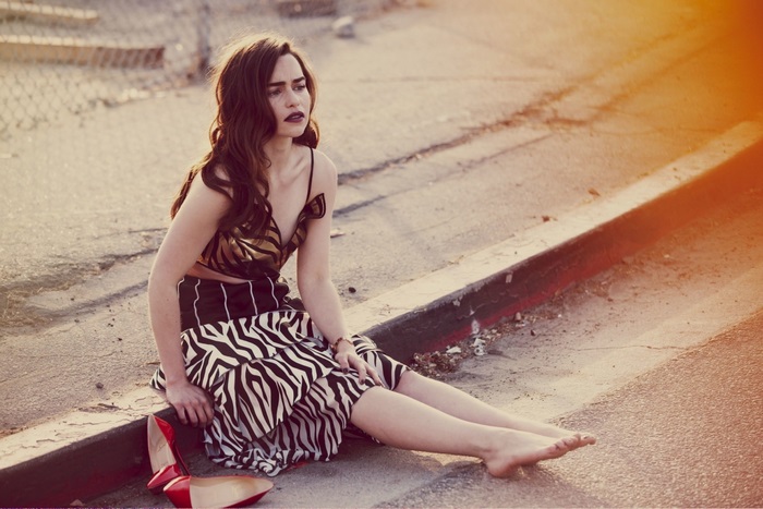 Emilia Clarke sitting by the curb