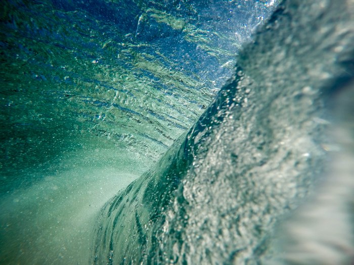 Underwater view of a breaking ocean wave with bubbles