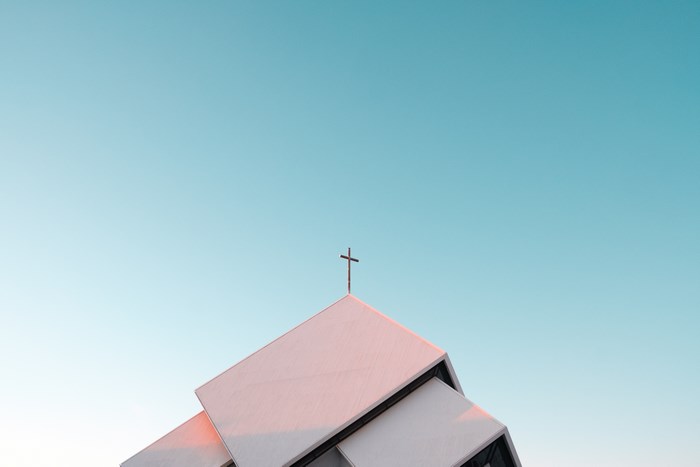 Modern Church Building with Cross Against Blue Sky