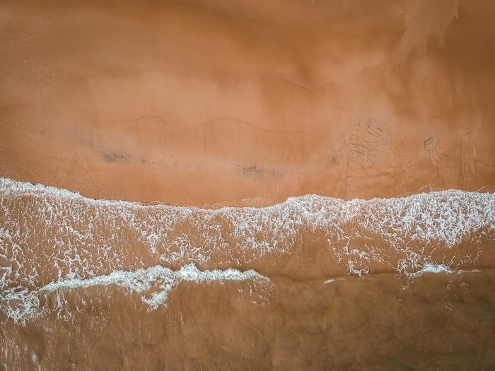 Aerial view of waves crashing on a sandy beach in Uruguay