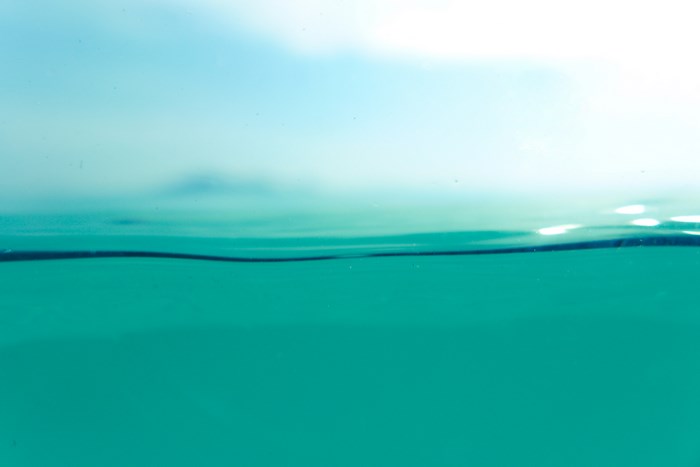 Turquoise water surface with blue sky above