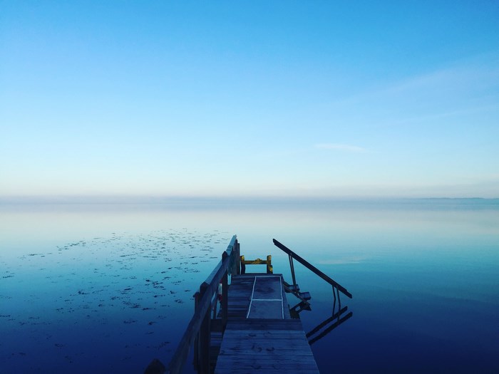 Wooden dock on a calm lake at dawn