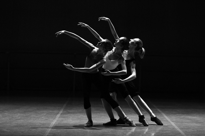 Three ballerinas dancing on stage