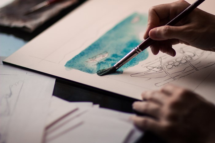 Artist painting a watercolor of a boat