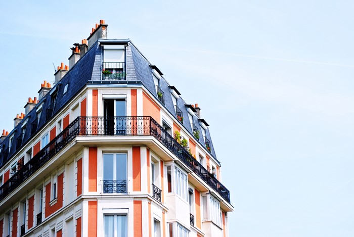 Corner of a Parisian building with orange and white facade