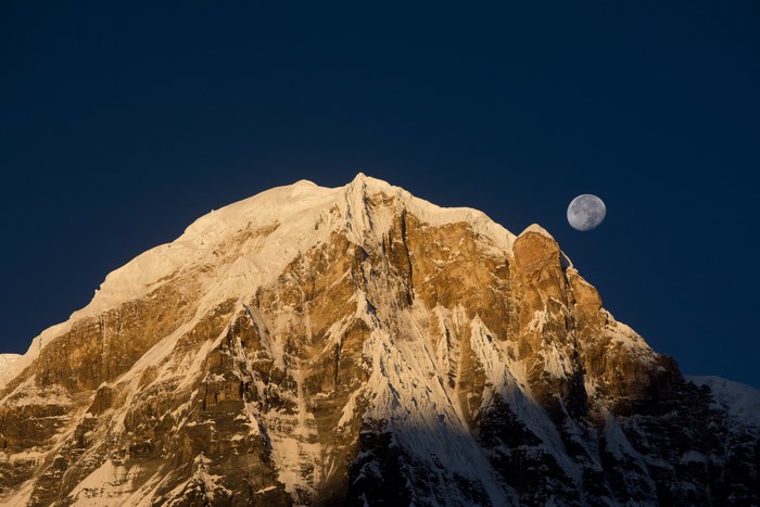 Annapurna mountain peak with moon in the sky