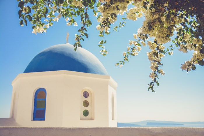 Blue dome church with white flowers and blue sky