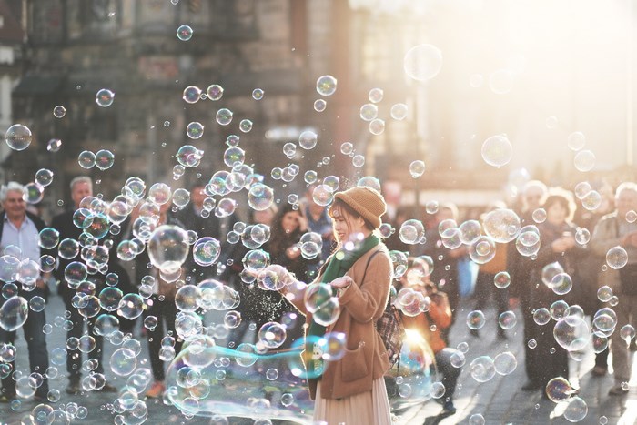 Woman blowing bubbles in a city street