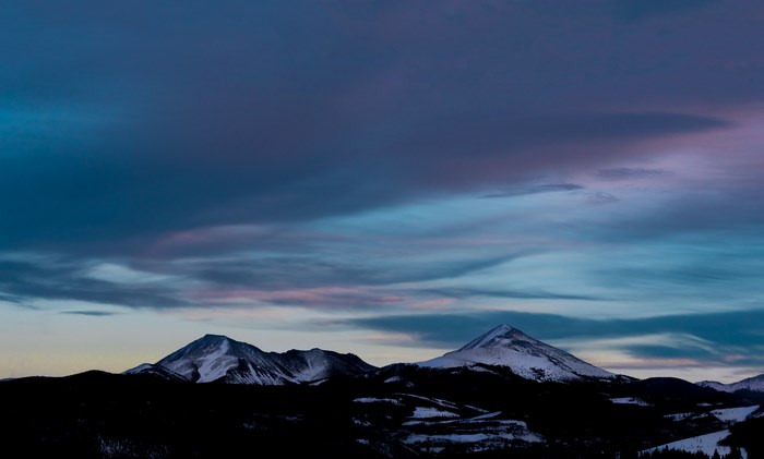 Snow-capped mountains under a colorful twilight sky