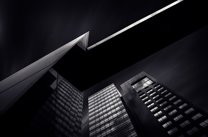 Black and white low-angle view of modern skyscrapers at night