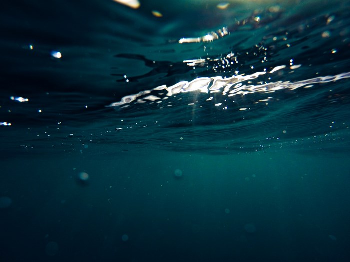 Underwater view of ocean waves and bubbles