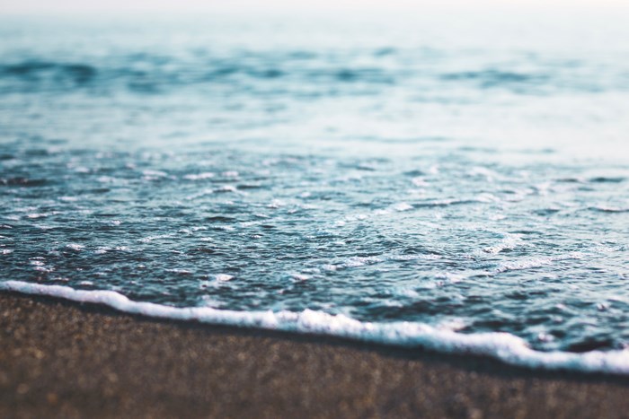 Close-up of ocean waves on a sandy shore