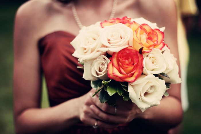 Woman in red dress holding a bouquet of roses