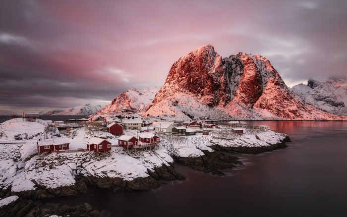Winter sunrise over a Norwegian village and snowy mountains