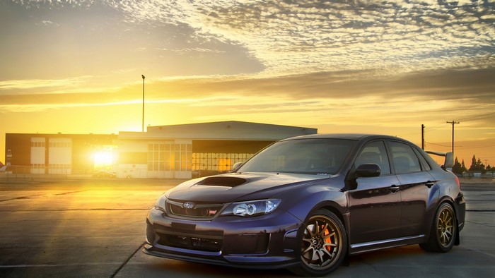 Purple Subaru WRX STI parked at sunset