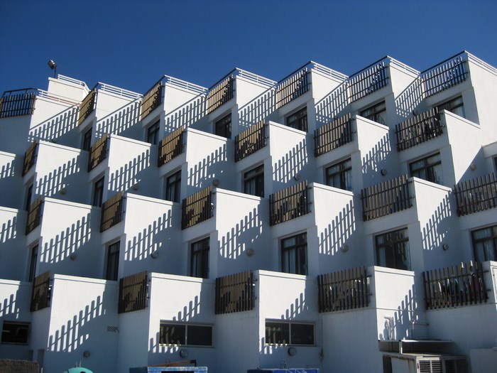 Geometric architecture of a white apartment building with shadows