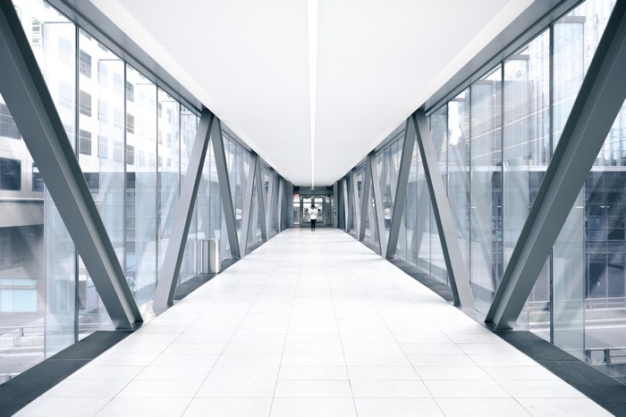 Modern glass skybridge with a person walking