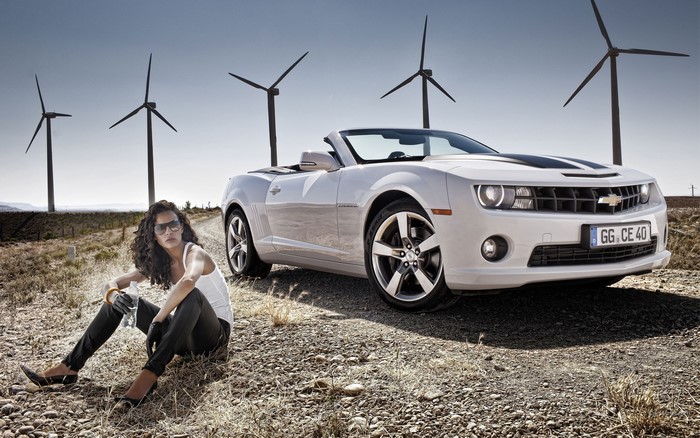 Woman with Chevrolet Camaro near Wind Turbines