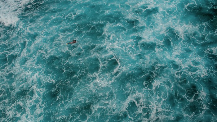 Aerial View of Surfer in Turquoise Ocean Waves