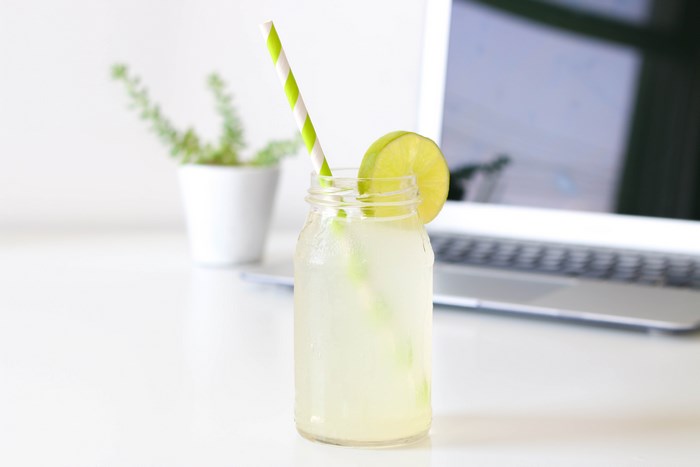 Lemonade in a jar with a lime slice and straw