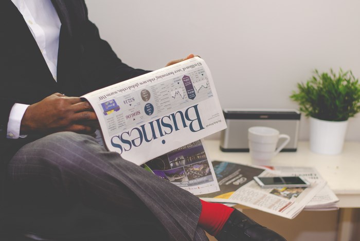 Man in Suit Reading Business Newspaper