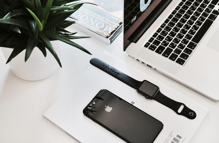Apple MacBook, iPhone, and Apple Watch on a desk