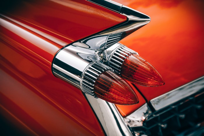 Close-up of a vintage red car's tail lights and fins
