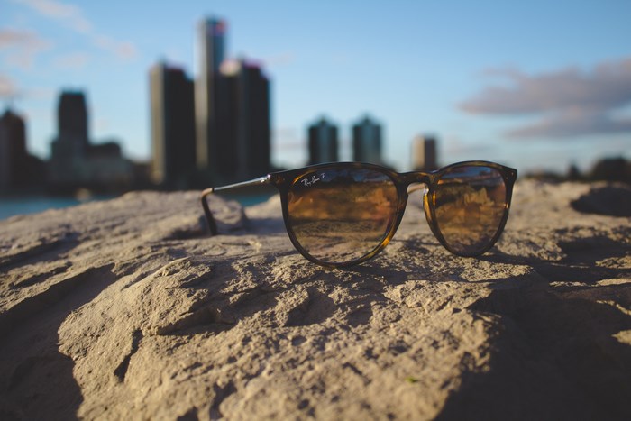 Ray-Ban sunglasses on a rock with Detroit skyline